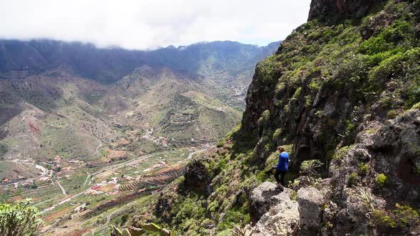 Man Climbing Rocks To Look From Mountainside