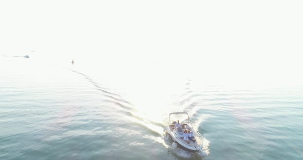 A Drone Shot of a Happy Family on a Summer Vacation Driving a Luxury Boat on the High Seas in the