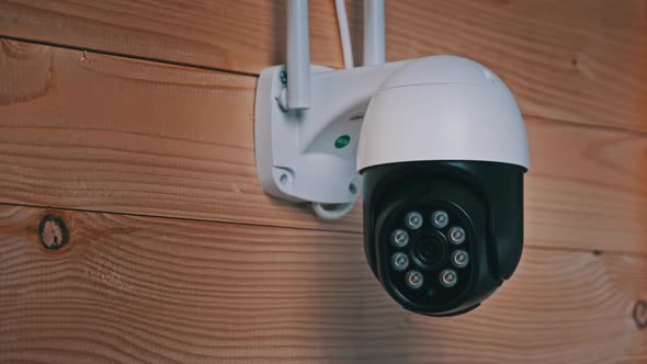 Security Camera Surveillance Rotates on Wooden Background