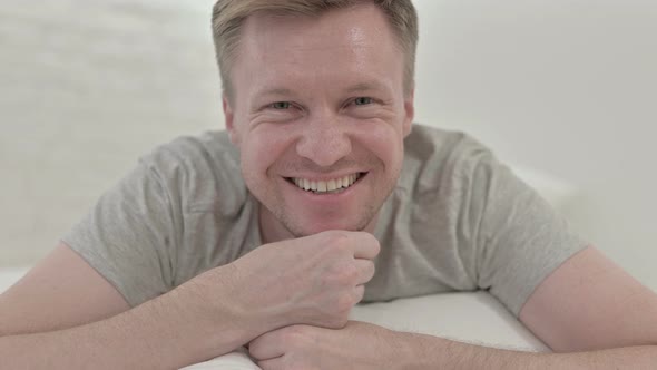 Close Up of Man Looking at The Camera and Smiling Lying in Bed