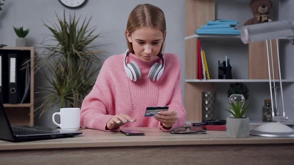 Blond Girl in Trendy Sweater Making Online Shopping Using Her Credit Card and Smartphone