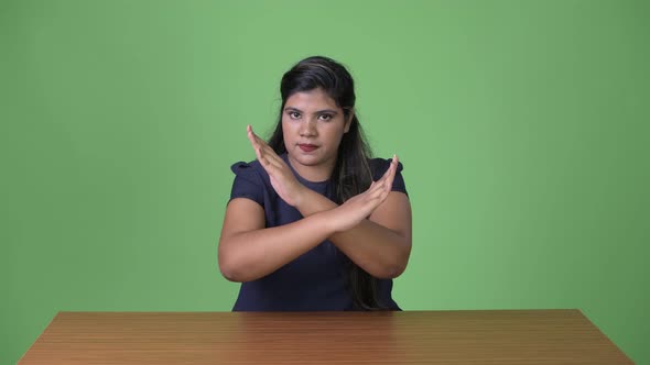 Young Overweight Beautiful Indian Businesswoman Against Green Background