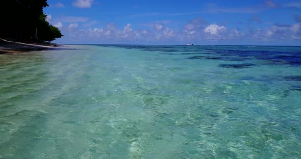 Daytime drone island view of a white sandy paradise beach and aqua blue ocean background in vibrant 