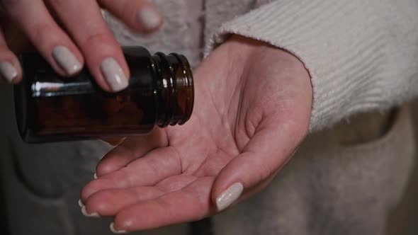 Closeup Woman Hands Holding White Pills From Dark Glass Bottle