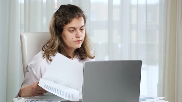 Disabled Woman Freelancer Works on Laptop From Home at Table