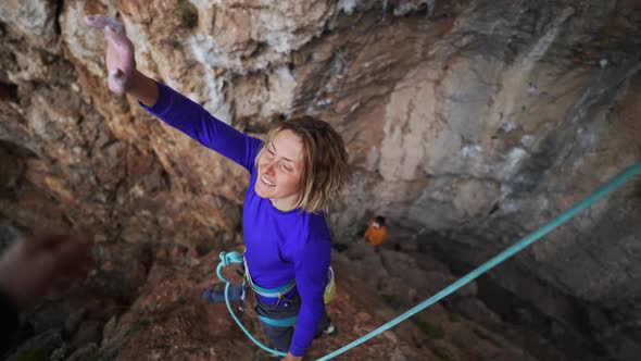 Joyful Woman Climber Give High Five After Successful Ascent of Route on Cliff