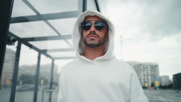 Happy Fashionable Man in Sportswear and with Glasses is Looking at Camera Outdoor