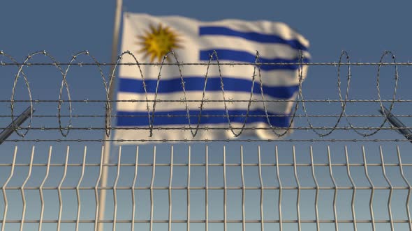 Waving Flag of Uruguay Behind Barbed Wire