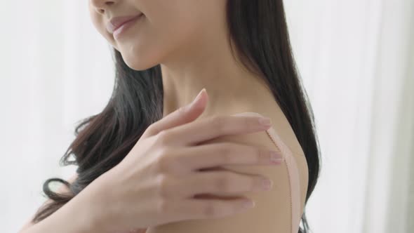 Beautiful sexy young asian woman applying cream on neck and message.