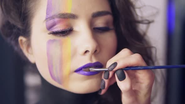 Makeup Artist Uses Brush to Apply Lipstick to Model's Lips