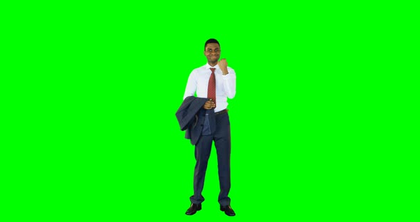 Excited businessman standing against green background