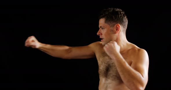 Man boxing on black background