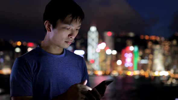 Asian man use of mobile phone at night 