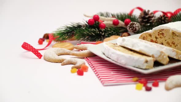 Sliced Traditional Christmas Stollen Cake on Ceramic Plate and New Year Decorations