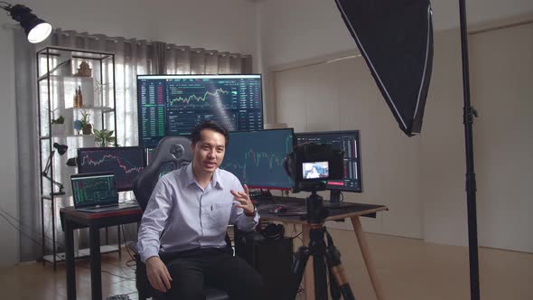 Asian Male Stock Market Broker Teaching How To Trade To Camera With Professional Light Equipment