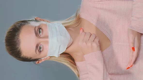 Pretty Blonde in Pullover and Face Mask Throws Pills on Palm