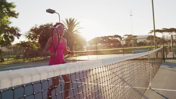 Video of happy african american female tennis player holding racket and hitting ball