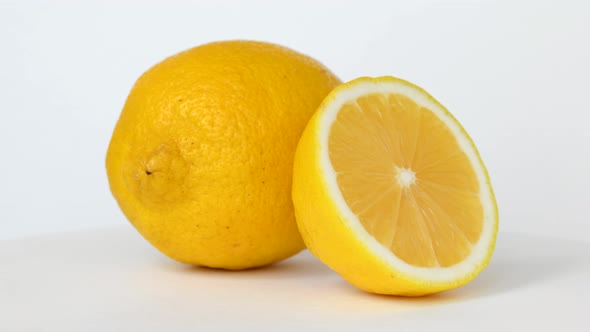 Whole and half lemon rotating on white background