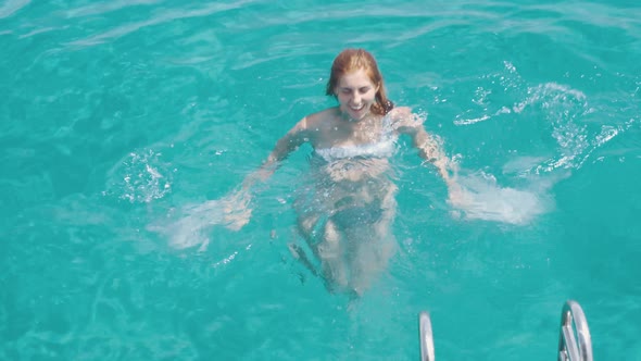 Beautiful Young Woman Swims in Clear Blue Water Near Formentera or Ibiza Islands Around Luxury Yach