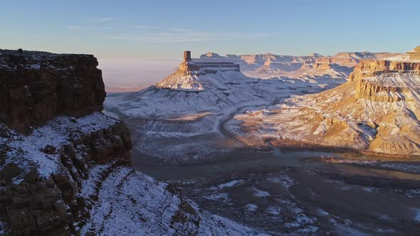 Aerial view panning across cliff viewing winter landscape in the Utah desert