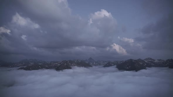 8K High Rocky Snowy Mountains Between Two Different Cloud Layers