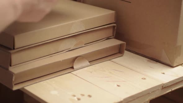 Hand moving cardboard boxes on a wooden pallet