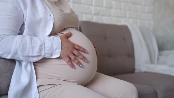 close up pregnant woman strokes her big belly. Maternity prenatal care