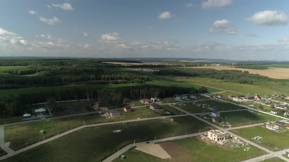 The shadow from the clouds covers cottage village next to the forest 08