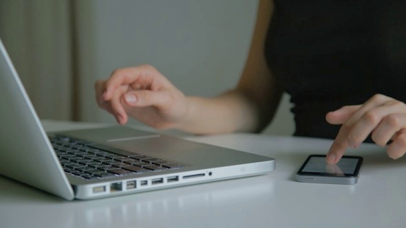 Woman Working On Laptop And On Smartphone