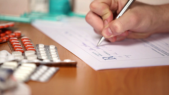 Pharmacist Writing Prescription On A Form