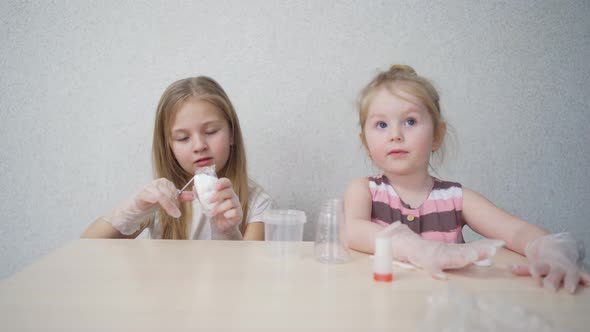 Cute Little Girls in Protective Gloves Prepare for Experiments at Home