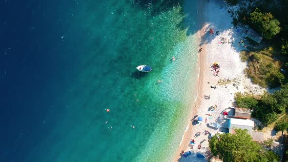 People Swimming On The Clear Water Sea During Summer In Croatia. - aerial spin