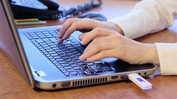 Woman Using Laptop and Inserting USB Flash Drive