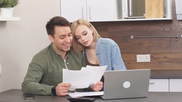 Young Married Couple with Paper Documents, Making Decision About House Purchase