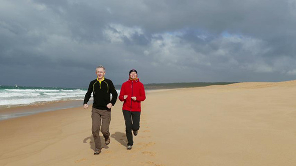 Middle-aged Couple Jogging on Beach