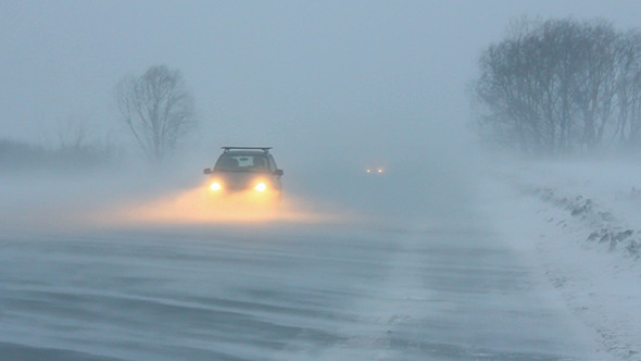 Cars On Winter Road At Blizzard