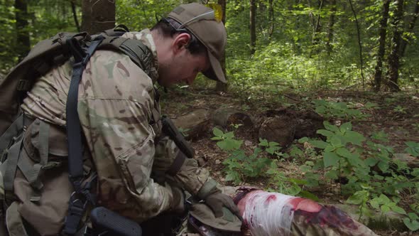 Combat Medic Providing Emergency Treatment to Injured Soldier Outdoors