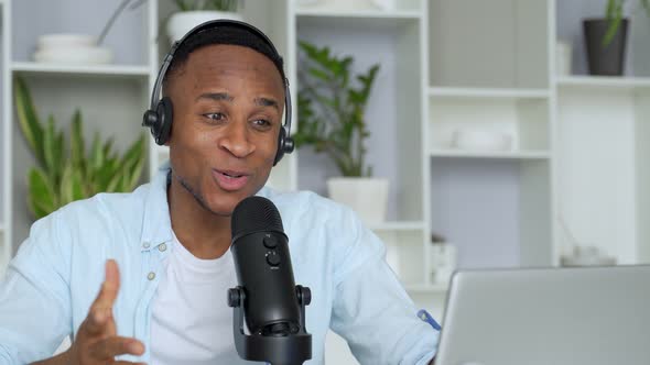 Podcast Concept - Happy Young Black Man Audio Blogger in Headphones with Laptop Computer and