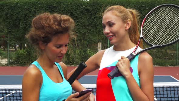 Tennis Girls Discussing While Sharing a Smartphone