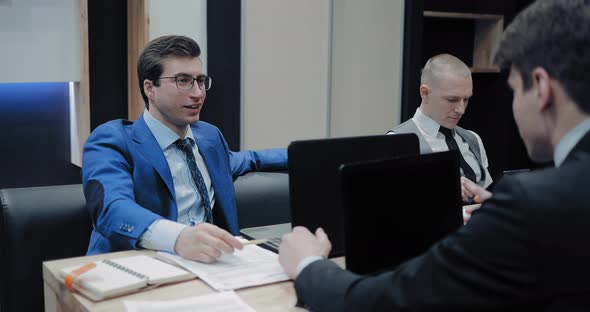 Young Businessmen Communicate in a Conference Hall