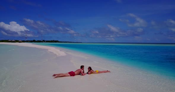 Romantic man and woman on honeymoon vacation have fun on beach on white sand 4K background