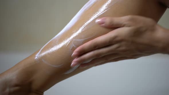 Female Hands Applying Moisturizing Body Lotion on Leg After Depilation, Hygiene