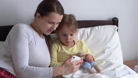 Caucasian Family Little Children Girl and Young Woman Mom Talking in Video Conference By Smartphone