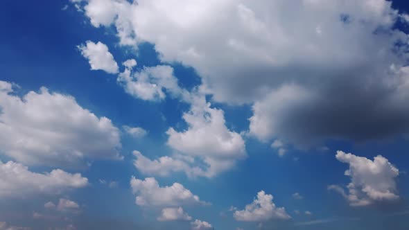 White puffy clouds and blue sky time-lapse with long second duration for background and graphics in