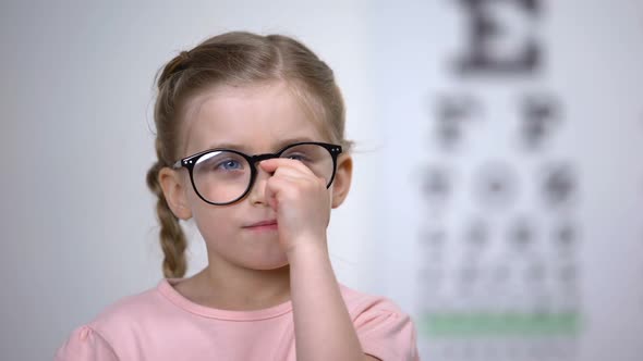 Adorable Female Child Smiling Adjusting Eyeglasses, Successful Vision Treatment