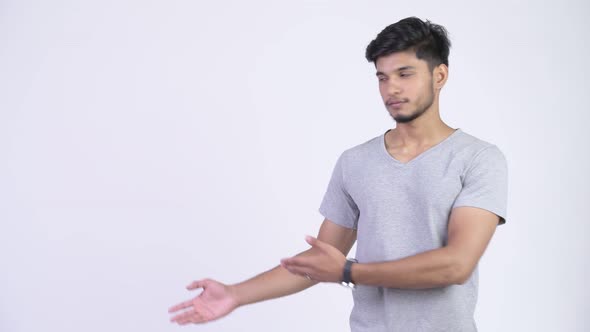 Young Happy Bearded Indian Man Showing Something