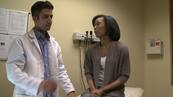 Doctor In Exam Room With Female Patient