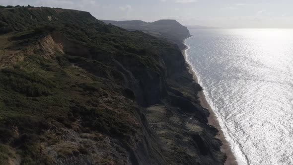 Charmouth beach and Golden cap aerial. Tracking forward east from Charmouth high above the beach. Su