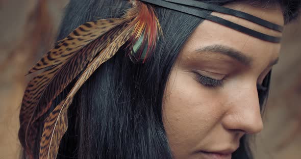Beautiful Young Indian Woman with Native Feathers in Her Hair, Looking