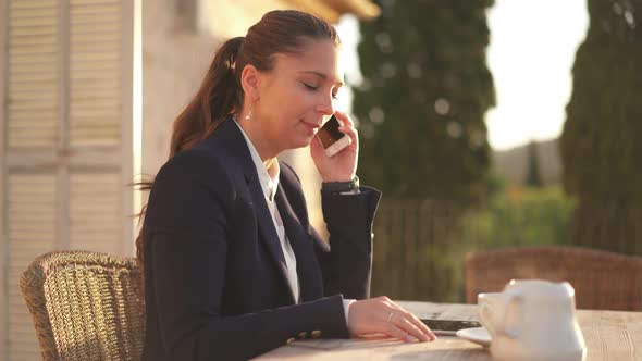 Business Woman Making Phone Call on Balcony During Small Breakfast